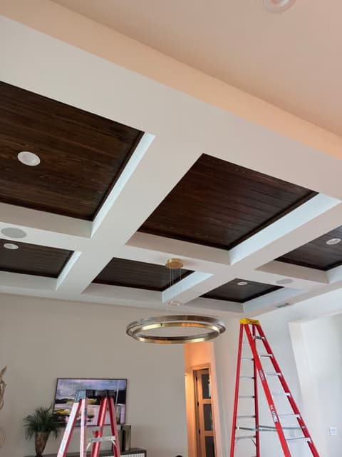 Coffered wood-beam ceiling with recessed lighting installed in a living room renovation