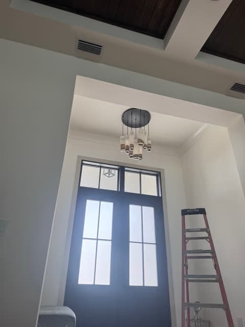 Front entry with tall glass-paneled double doors and a new pendant light fixture