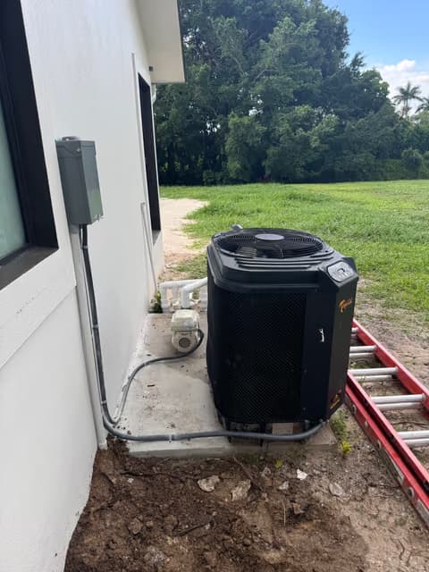 New outdoor air conditioning condenser unit installed beside a house