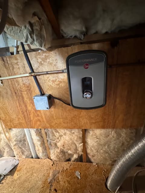 Tankless water heater mounted between wall studs during installation