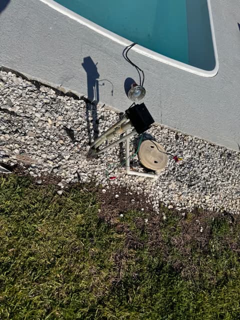 Pool equipment and electrical box mounted near an in-ground pool