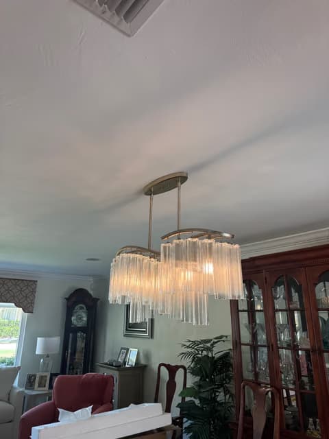 Multi-tier crystal chandelier installed above a dining room table