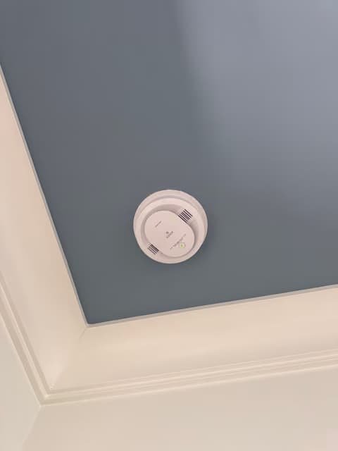 Smoke detector installed on a bedroom ceiling