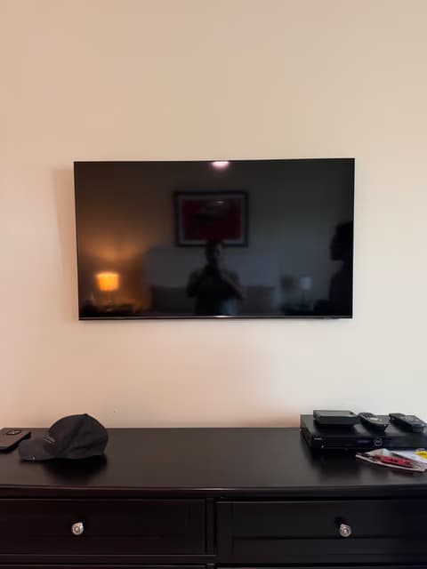 Wall-mounted flat-screen TV installed above a media console