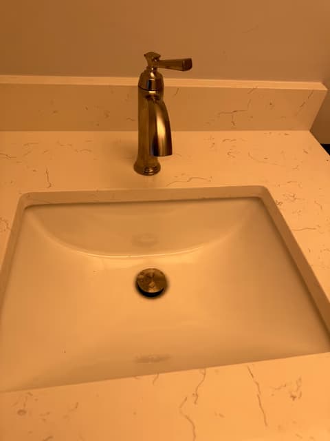 Bathroom vanity sink with a new bronze faucet installed