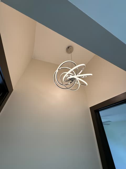 Decorative wire-sculpture wall light fixture installed