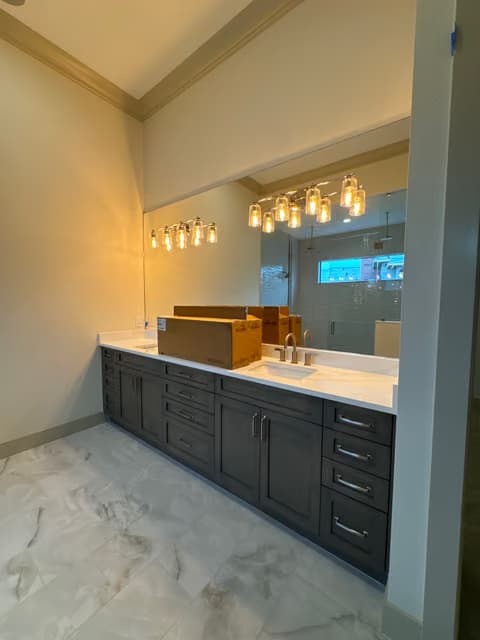 Bathroom double vanity with new pendant lighting and dark cabinetry