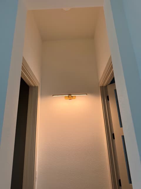 Hallway with a new pendant light and wall sconce installed