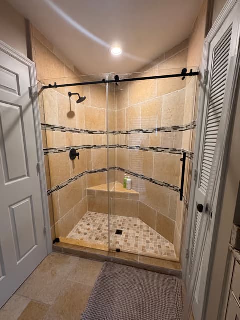 Glass-enclosed tile shower with a sliding barn-style door