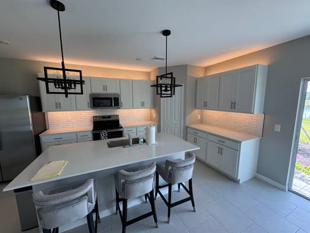Kitchen island with new pendant lighting and bar seating
