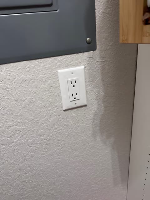 New wall outlet installed on a textured interior wall