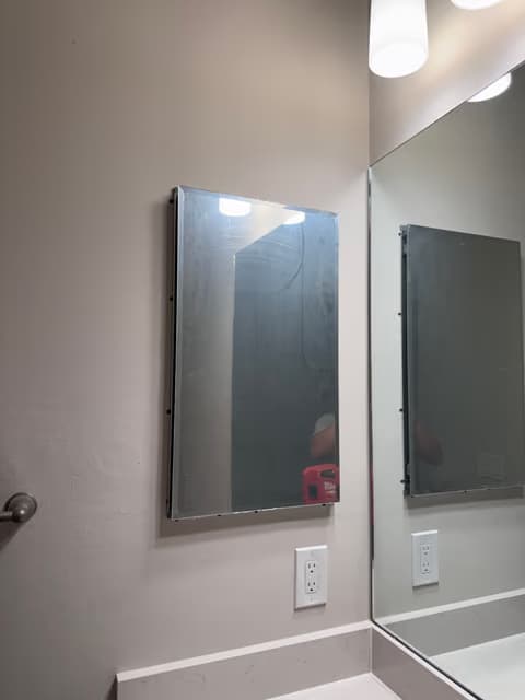 Bathroom mirror and vanity light installed above a sink