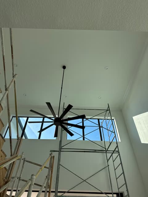 Large ceiling fan installed in a vaulted ceiling with scaffolding still in place
