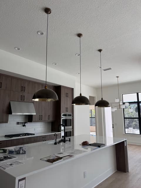 Kitchen island with pendant lighting and dark cabinetry