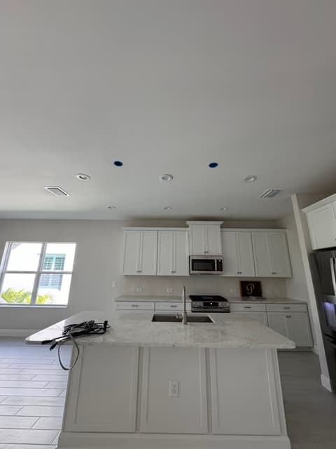 White kitchen cabinets being installed during a renovation