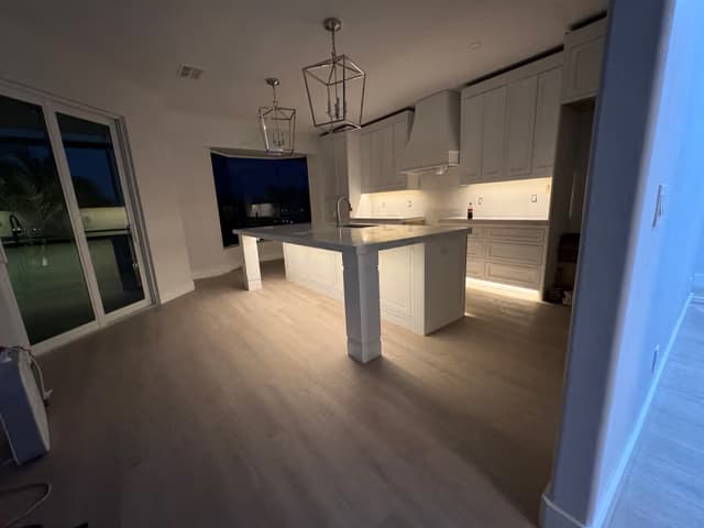Open-concept kitchen and living area with new wood flooring
