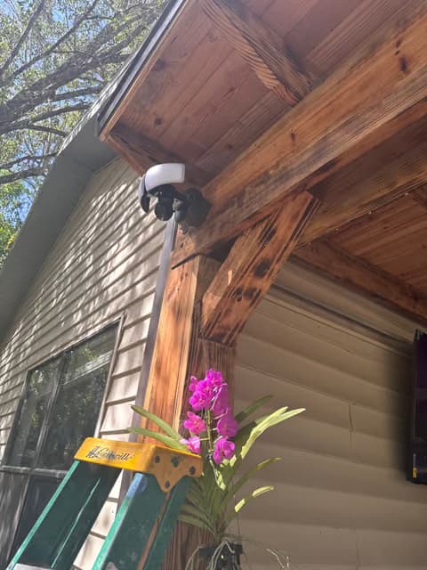 Security camera mounted under a wood eave