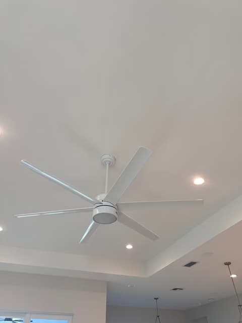 Large ceiling fan installed in a tray ceiling with recessed lighting