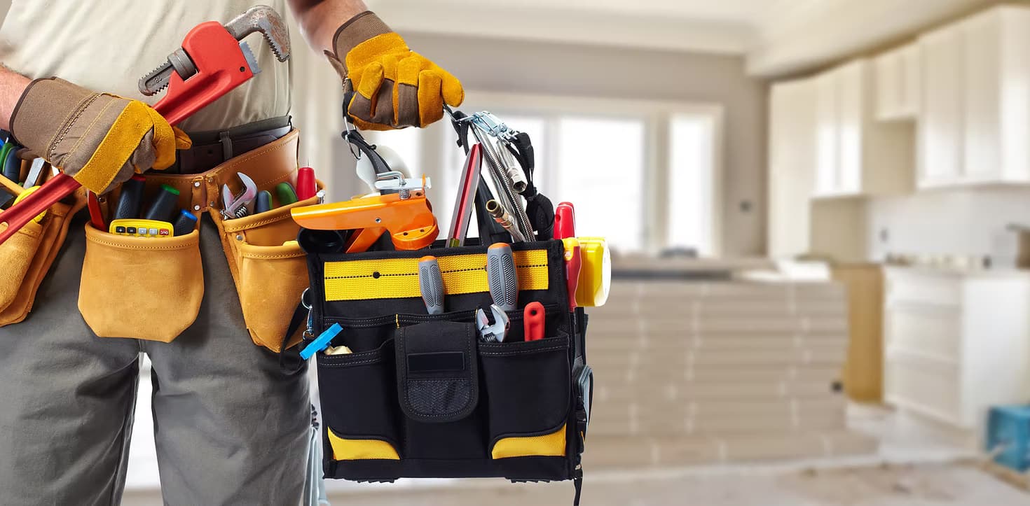 KirchCo handyman carrying a tool belt and toolbox, ready to work in a kitchen renovation